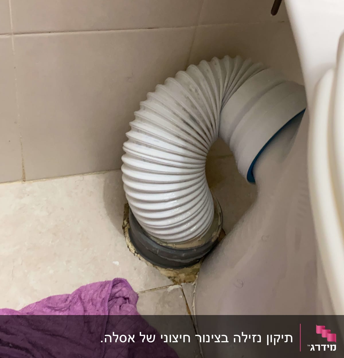 צינור גמיש מחובר לאסלה בחדר אמבטיה